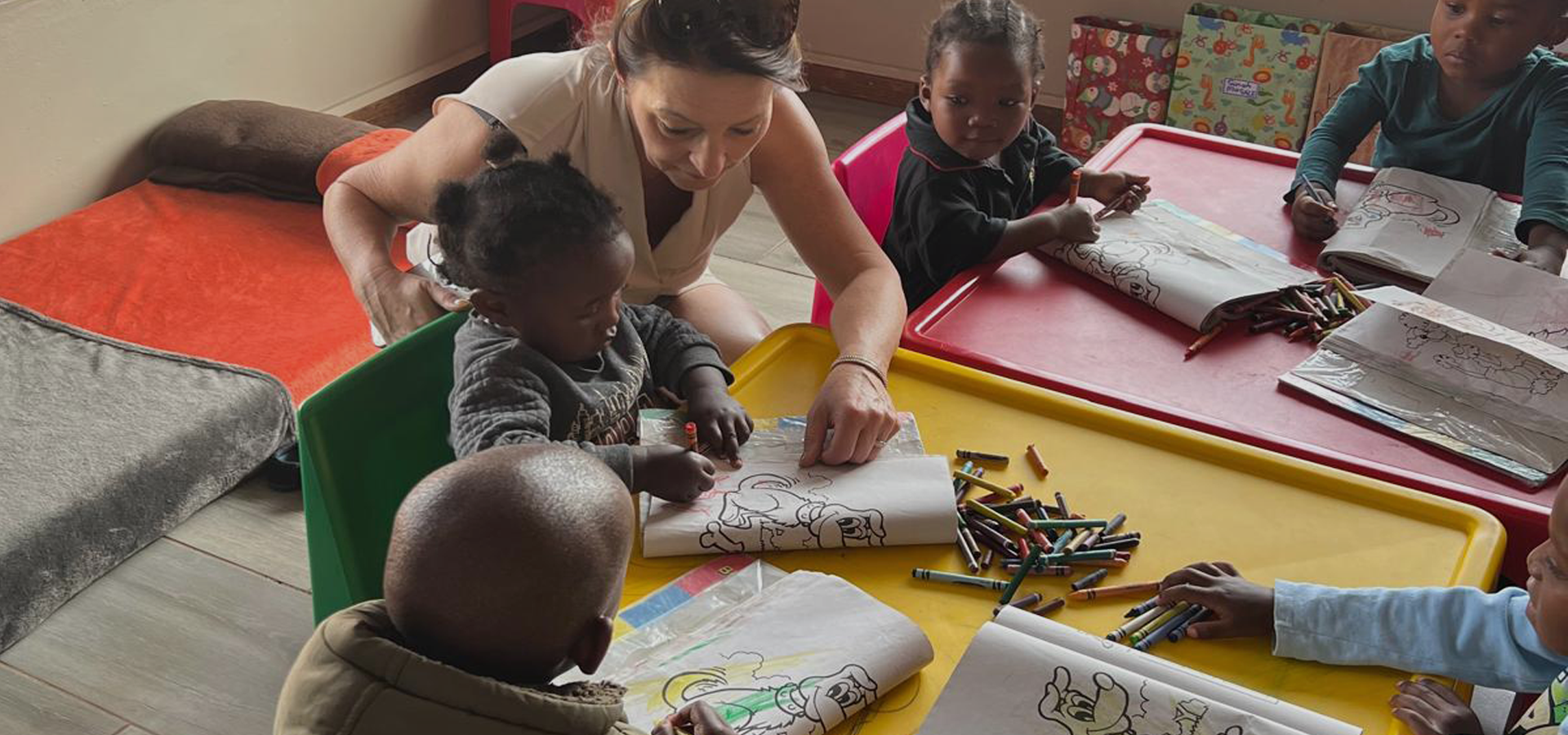 South Africa woman helping young children in classroom